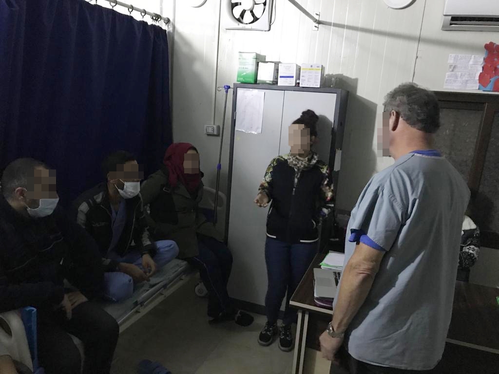Training al-Hol März 2020 2 Drei Personen sitzen auf einem Patientenbett im Krankenhaus und hören den Ausführungen der Dozent*innen zu.